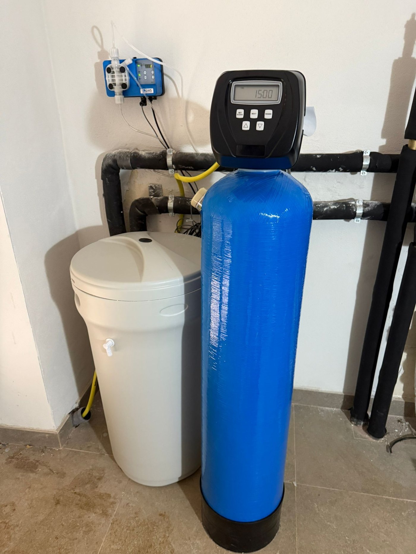 Addolcitore e colonna di filtrazione dell'acqua installati in un locale tecnico a Bari